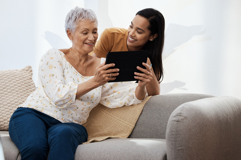So how do you download an app. a senior woman using a digital tablet with her daughter on the sofa at home. So how do you download an app. a senior woman using a digital tablet with her daughter on the sofa at home — Photo