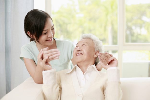 Woman giving senior woman a surprise Woman giving senior woman a surprise