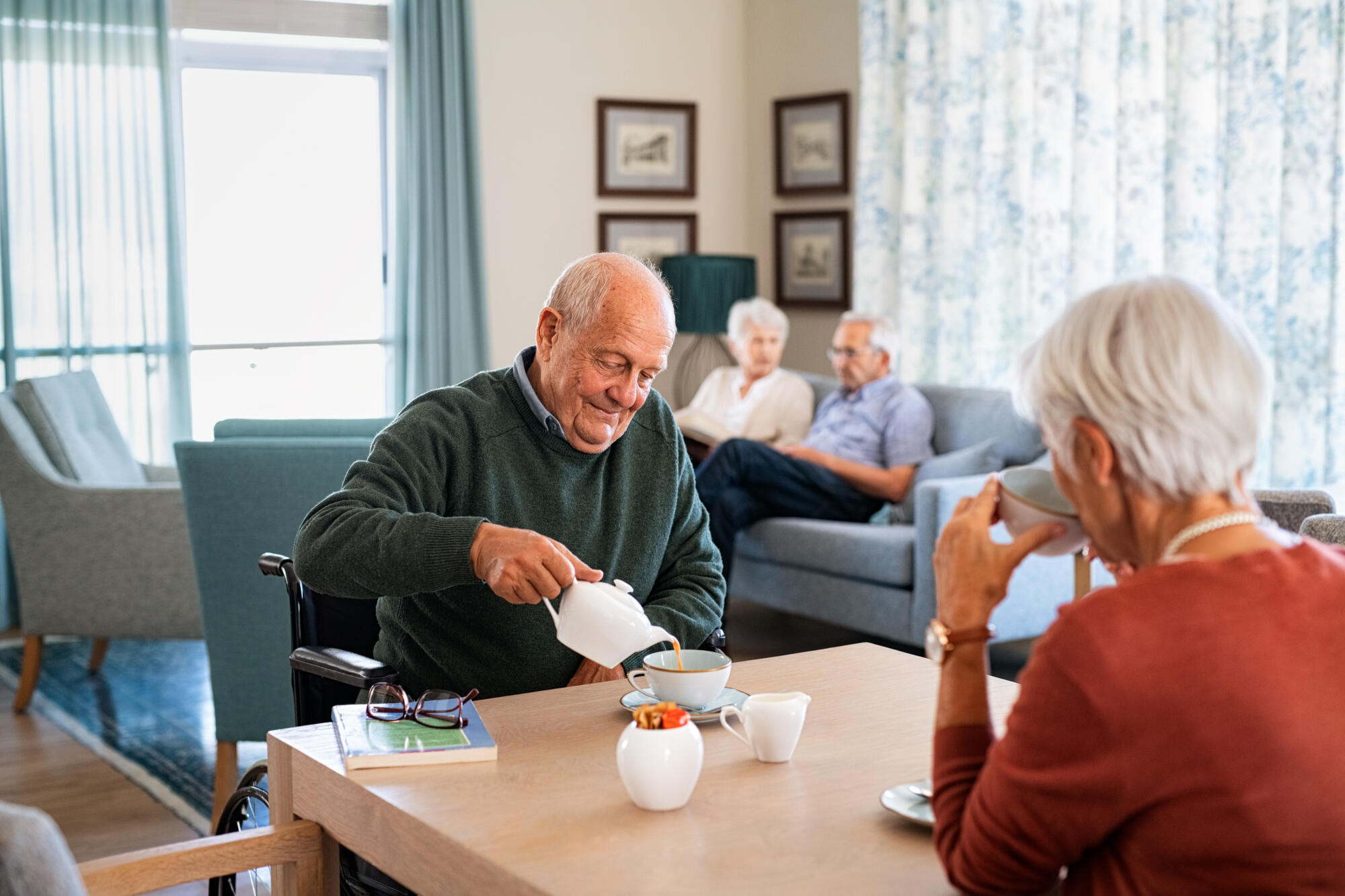 Smiling,Senior,Man,Pouring,Tea,In,Cup,From,Teapot,In