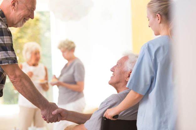 Two,Elder,Men,Smiling,And,Shaking,Hands,During,Meeting,At