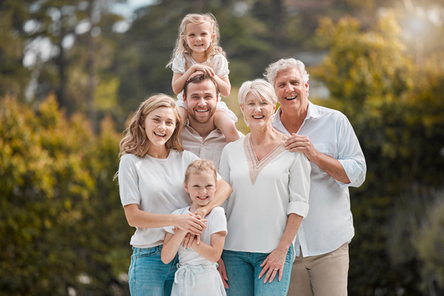 portrait-smiling-multi-generation-caucasian-family-standing-close-together-garden portrait-smiling-multi-generation-caucasian-family-standing-close-together-garden
