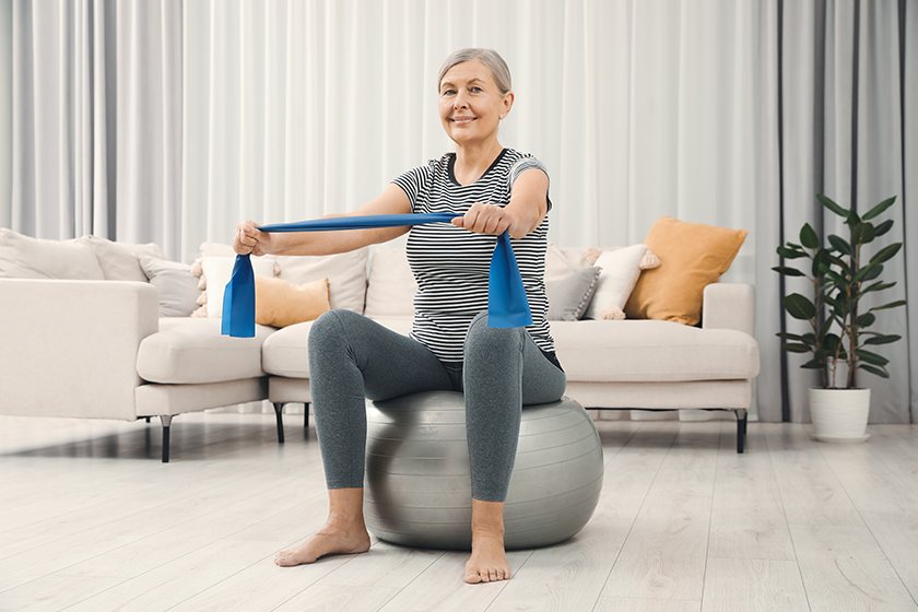 senior-woman-doing-exercise-elastic-resistance-band-fitness-ball-home senior-woman-doing-exercise-elastic-resistance-band-fitness-ball-home