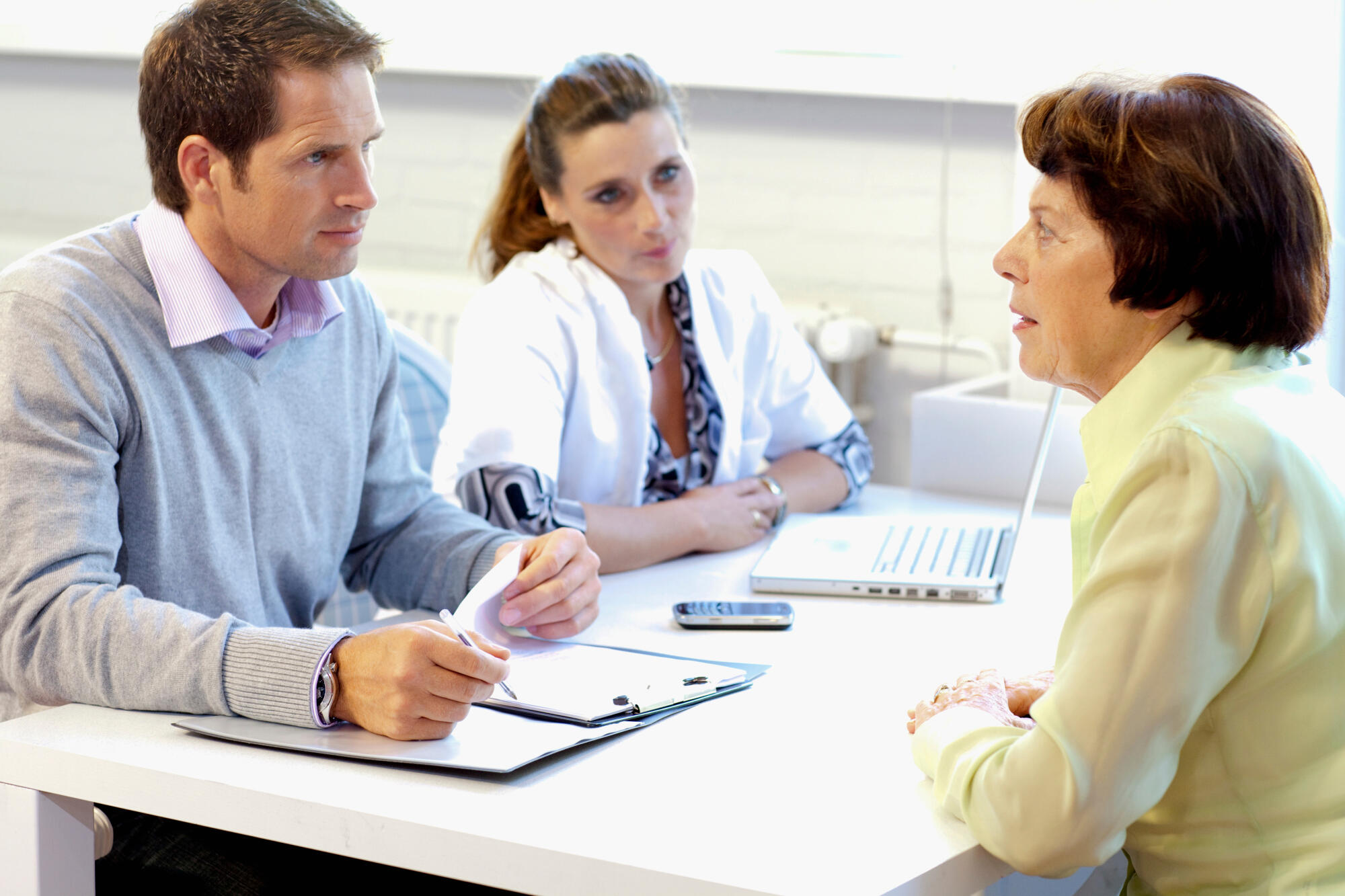 A,Resident,Talking,To,Care,Assistants,In,A,Retirement,Home