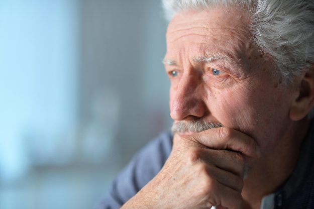 Portrait of old sad man at home