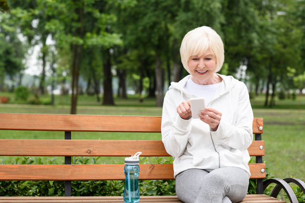 Senior woman using smartphone while sitting