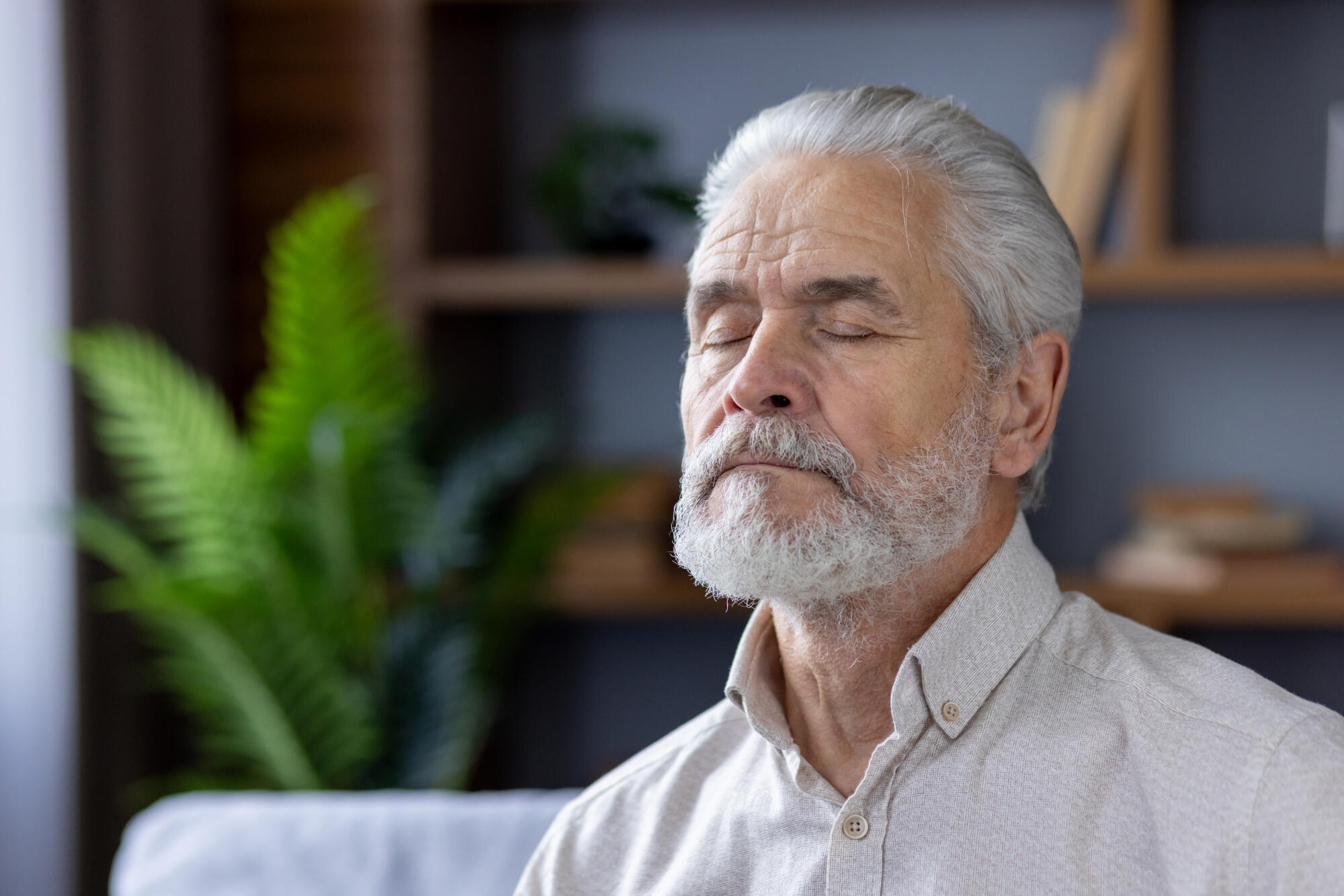 Senior man meditating peacefully in a modern home