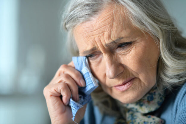 Portrait of sick senior woman at home