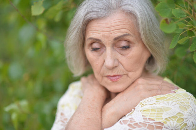 Portrait of sad seniour woman in park