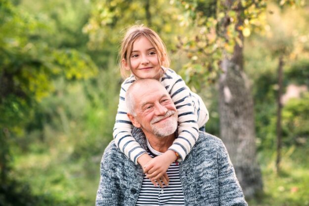 Grandfather,Carrying,His,Grandaughter,On,His,Shoulders.